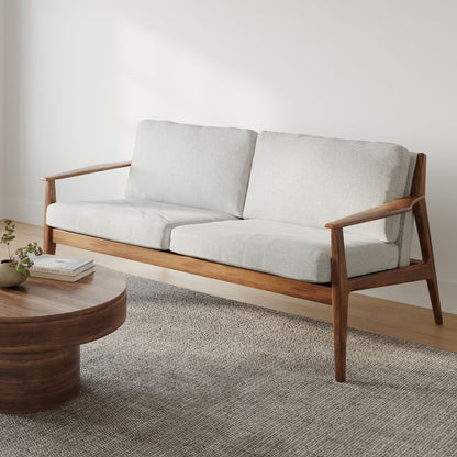 Wooden sofa with white cushions in a minimalistic room.