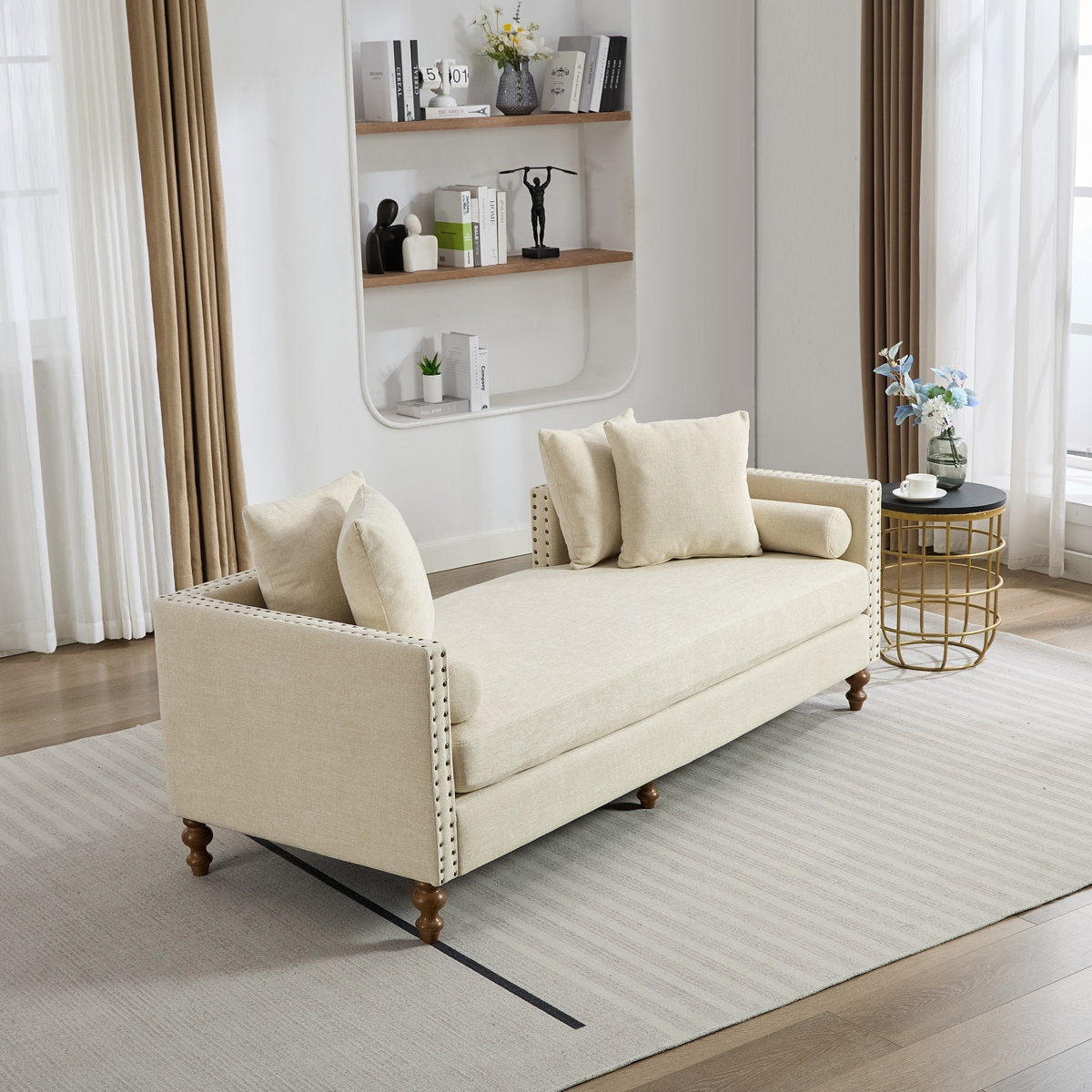 Beige sofa in a living room with a bookshelf and decorative items.
