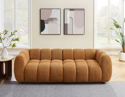 Brown sofa in a living room with abstract art on the wall and plants.