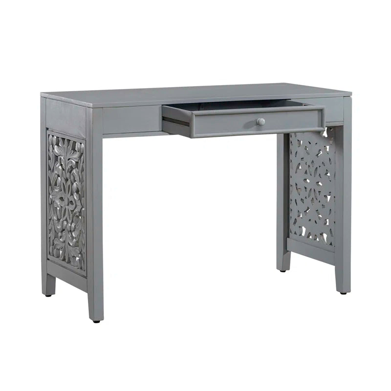 Gray desk with decorative front panel and drawer on a white background