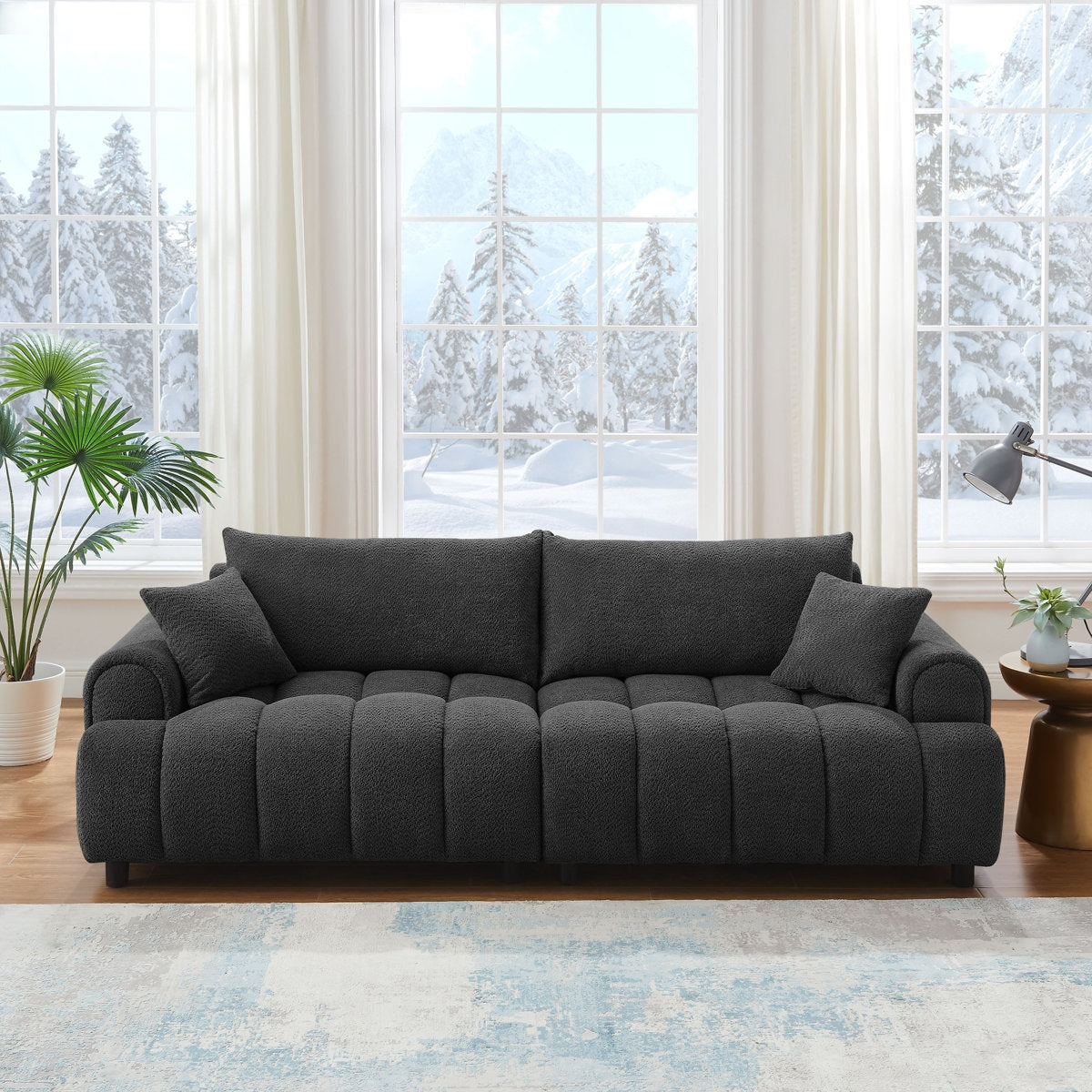Gray sofa in a living room with large windows showing a snowy outdoor view.