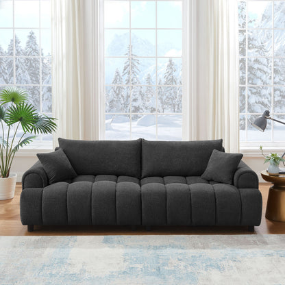 Gray sofa in a living room with large windows showing a snowy outdoor view.