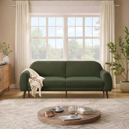Green sofa in a living room with a wooden coffee table and plants.