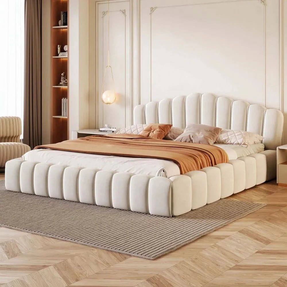 Modern bedroom with a large upholstered bed, wooden floor, and decorative elements.