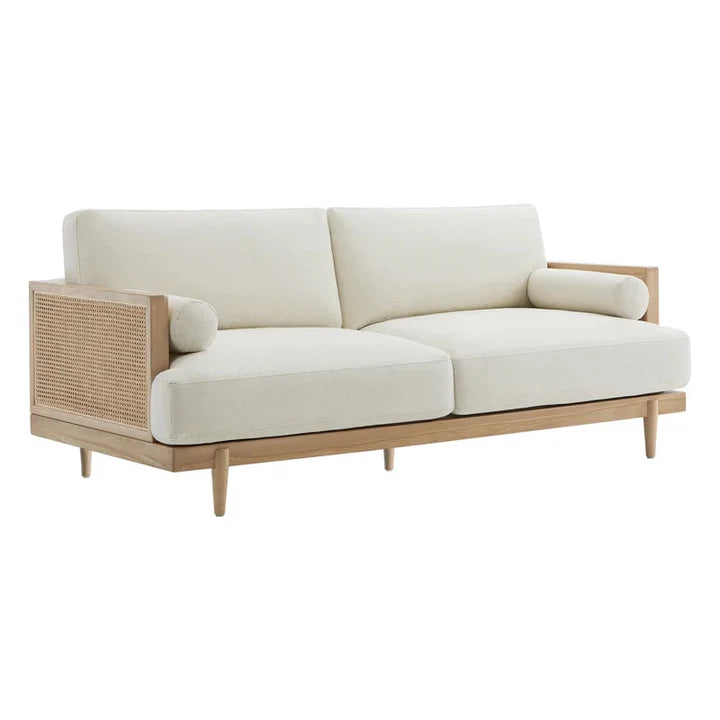 Beige sofa with wicker accents on a white background