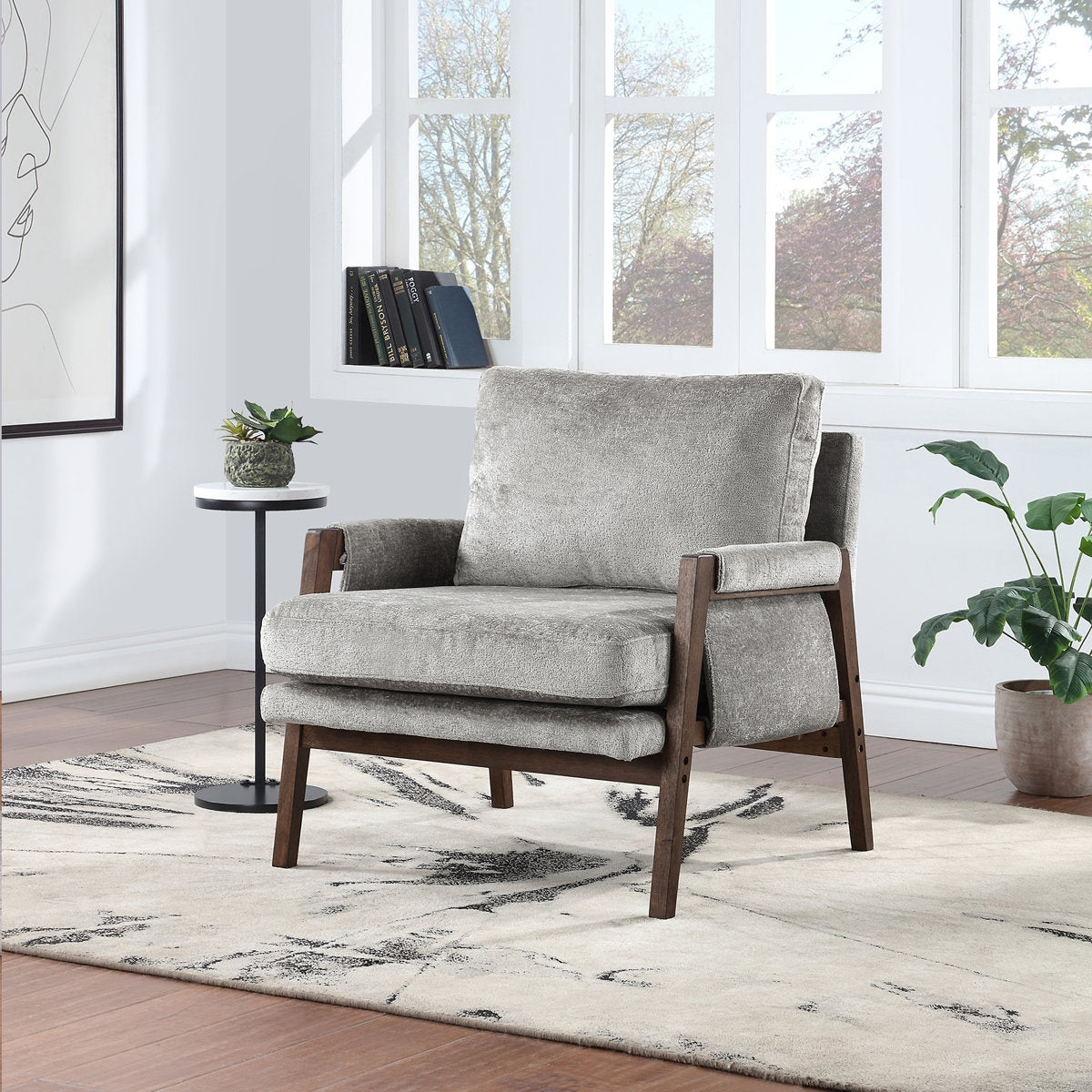 Gray armchair in a modern living room with a rug and plants.