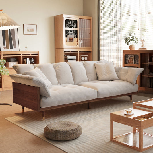Modern living room with a beige sofa, wooden coffee table, and bookshelves.