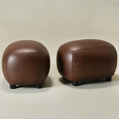 Two brown leather ottomans on a beige background