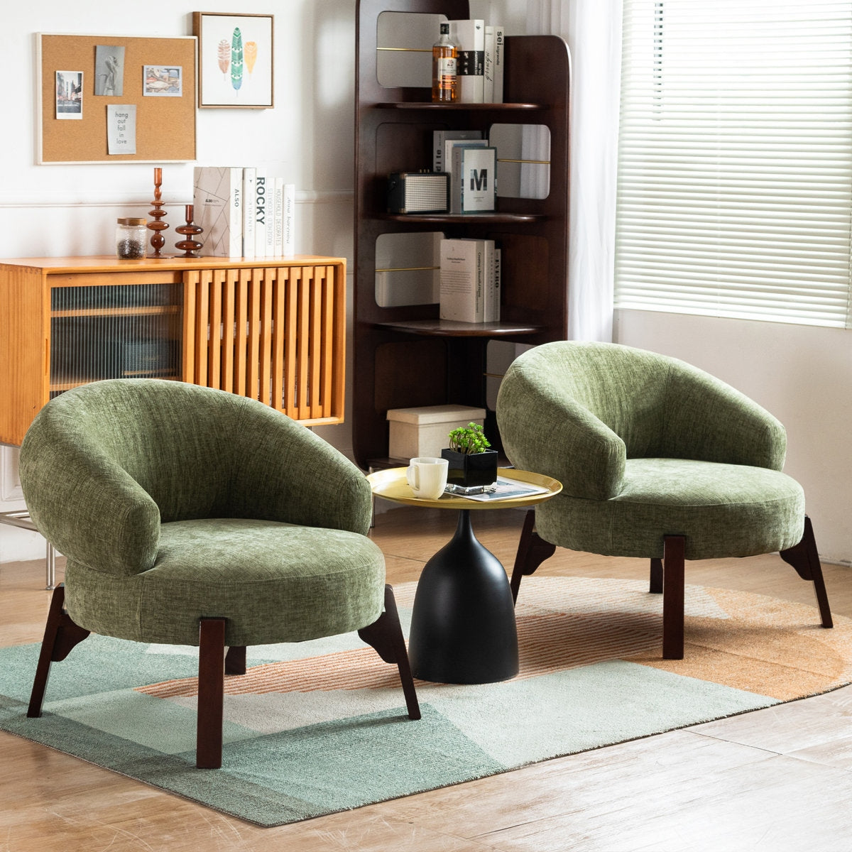 Two green armchairs in a living room with a small round table and bookshelf.