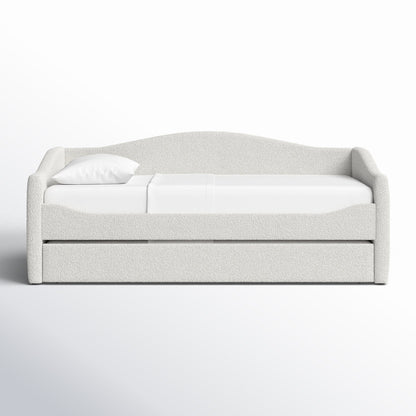 White upholstered bed with a pillow on a white background