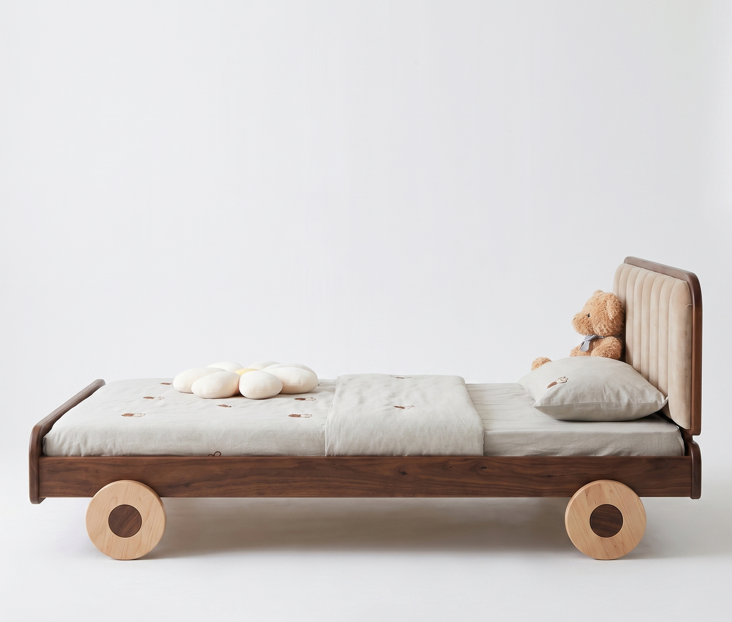 Wooden bed with wheels and a teddy bear on a white background
