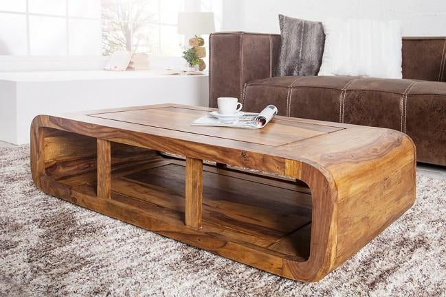 Wooden coffee table in a living room setting with a brown sofa and rug.