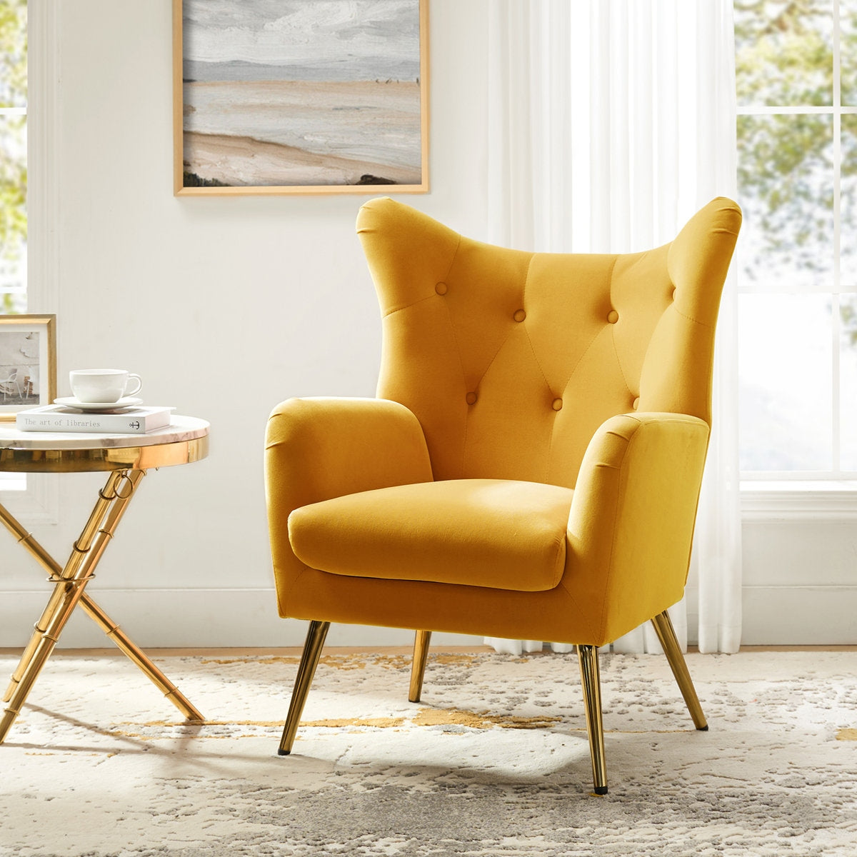 Yellow armchair in a bright room with a small table and artwork on the wall.