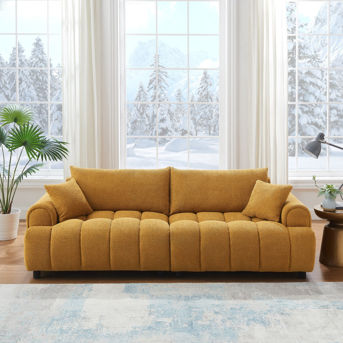 Yellow sofa in a living room with large windows showing a snowy outdoor view.