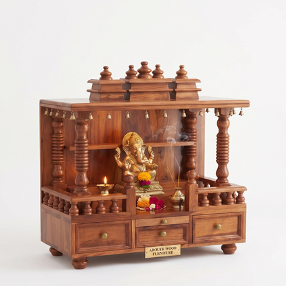 A wooden Shiva Ganesh home altar with a carved gold statue, a small brass candle, incense sticks, and decorative flowers, set against a plain white background.