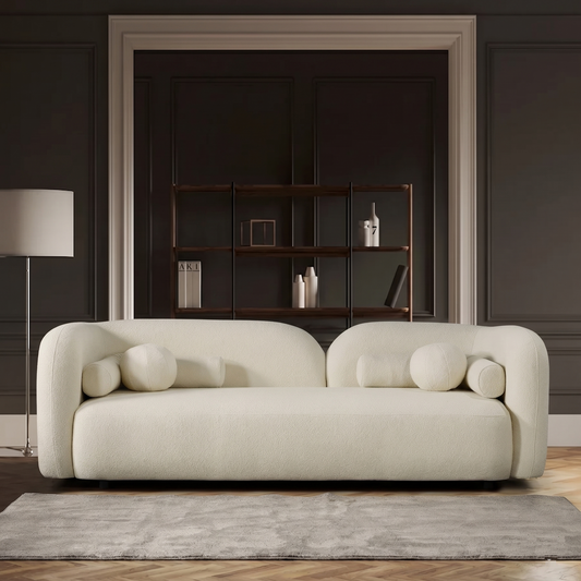 Modern  white sofa in a stylish room with a bookshelf and lamp.