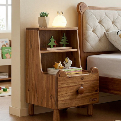 Wooden nightstand with decorative items next to a bed in a bedroom.