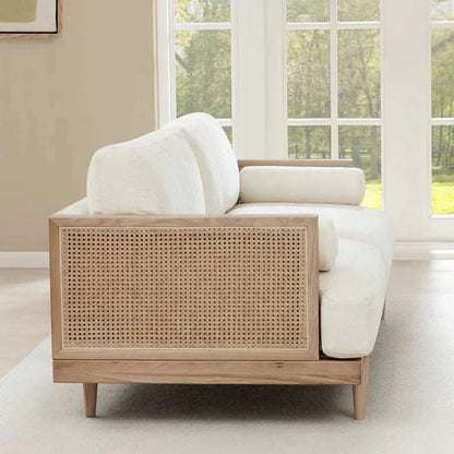 Sofa with wicker backrest in a room with large windows