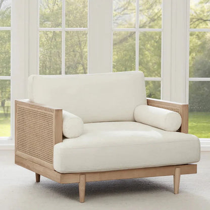 A cream upholstered three-seater sofa with solid wood cane frame, positioned in a well-lit room with a light color scheme.