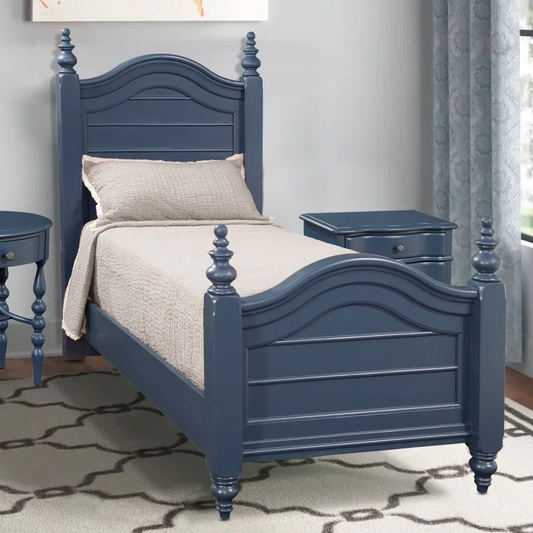 A blue, handcrafted solid sheesham wood children's bed with a storage drawer underneath, placed in a bedroom setting with a decorative pillow on it.