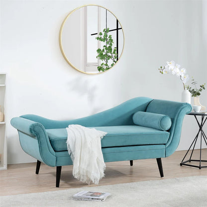 Turquoise chaise lounge in a living room setting with a round mirror and plant.