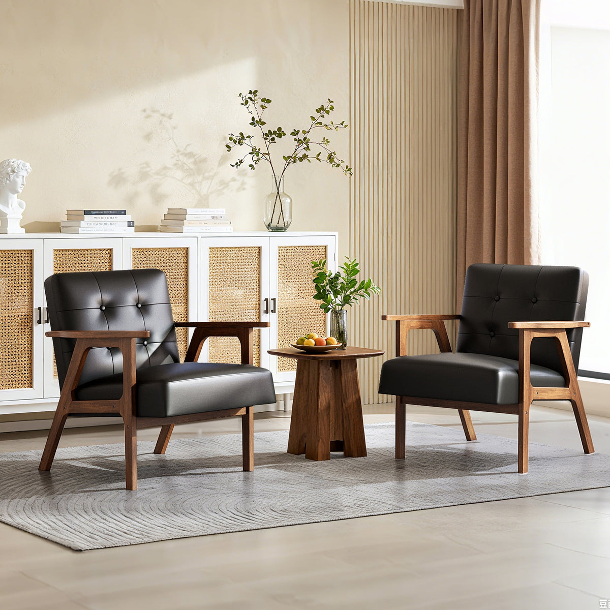 Two black leather armchairs in a living room setting with a small table and decorative items.