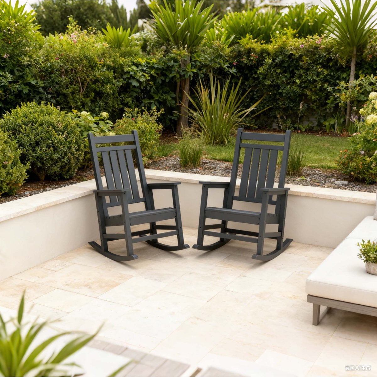 Two gray rocking chairs on a patio with greenery in the background