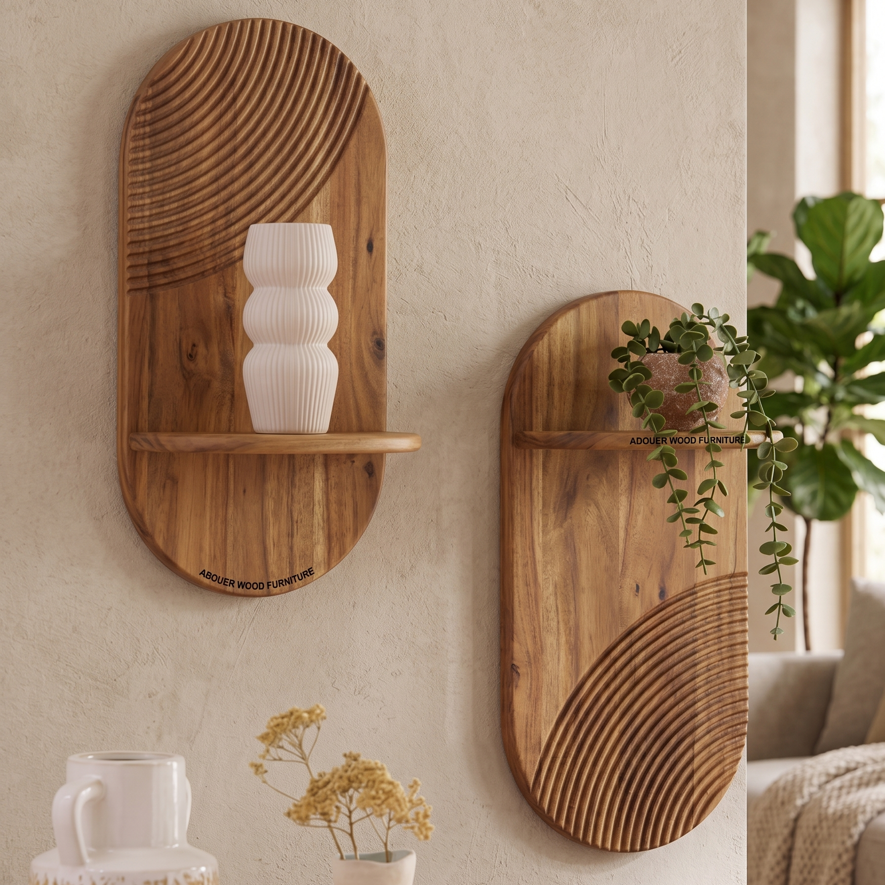 Two oval wooden wall-mounted shelves with carved linear patterns, displayed on a textured beige wall in a styled interior setting. One shelf holds a white ribbed vase, and the other has a trailing green plant.