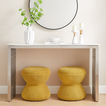 Two yellow stools in front of a white console table with decorative items.