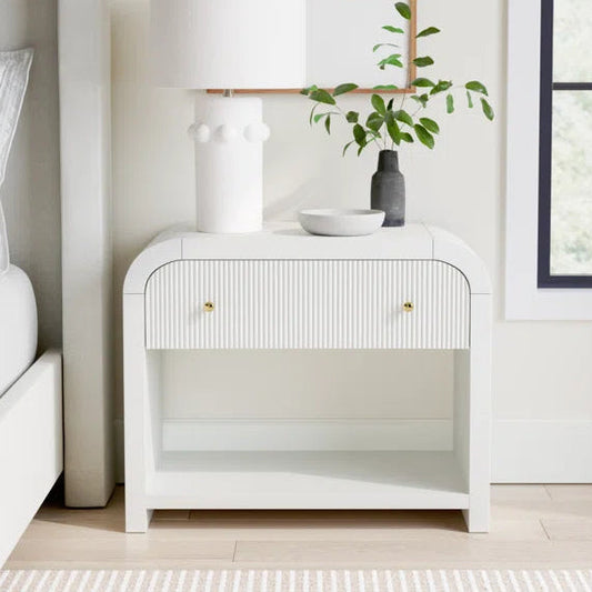 White nightstand with decorative items in a bedroom setting