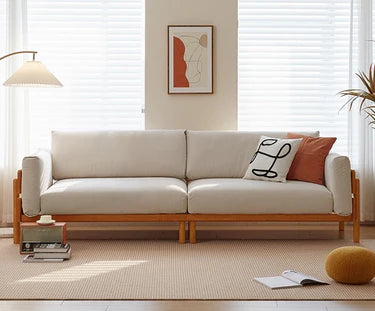 White sofa with wooden frame in a living room setting