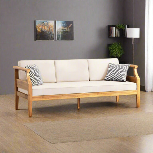 White sofa with wooden frame in a room with gray walls and a lamp.