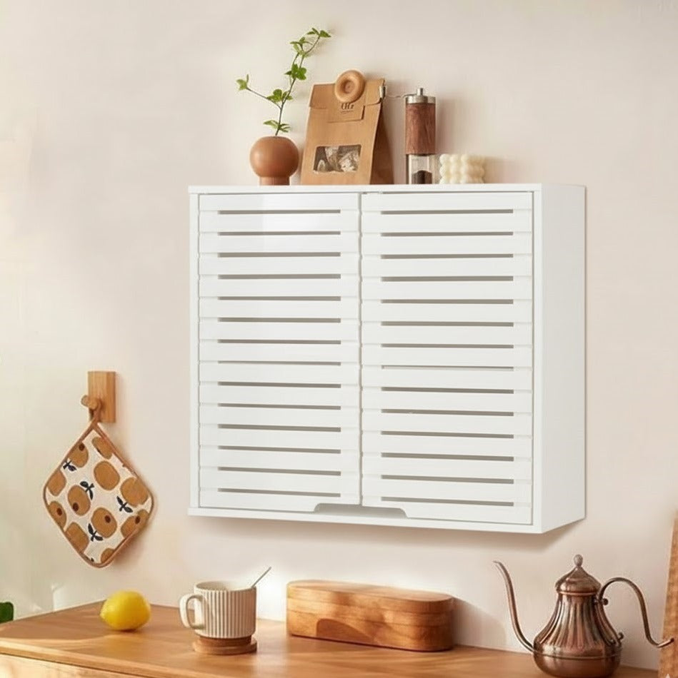White wall-mounted cabinet with decorative items on a light-colored wall.