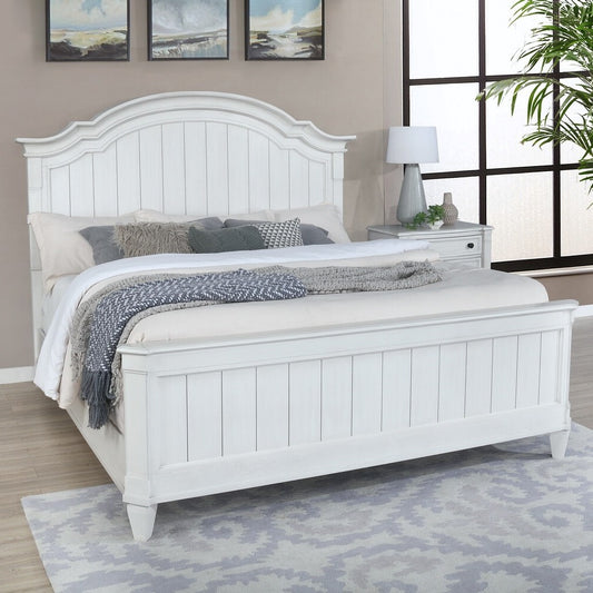 White wooden bed in a bedroom setting with a lamp and decor.
