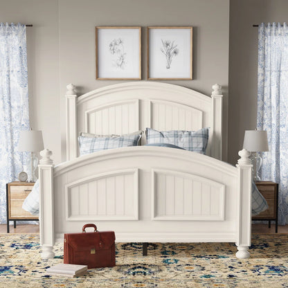 White wooden bed in a bedroom with nightstands, lamps, and decorative pillows.