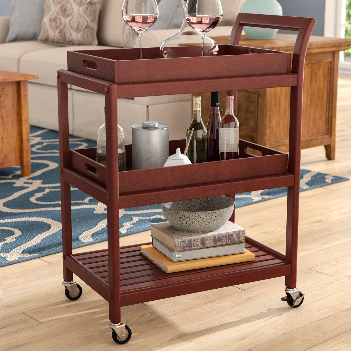 Wooden bar cart with wine bottles and glasses in a living room setting