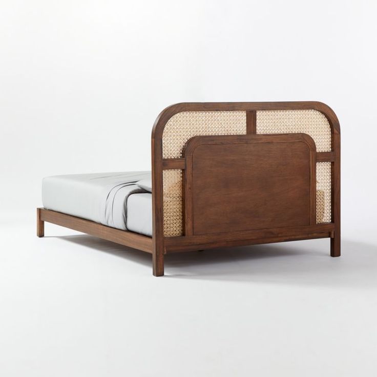 Wooden bed frame with wicker accents on a white background