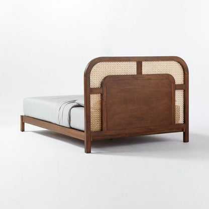 Wooden bed frame with wicker accents on a white background