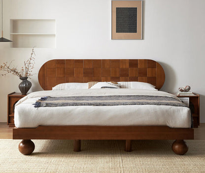 Wooden bed with a patterned headboard in a bedroom setting.
