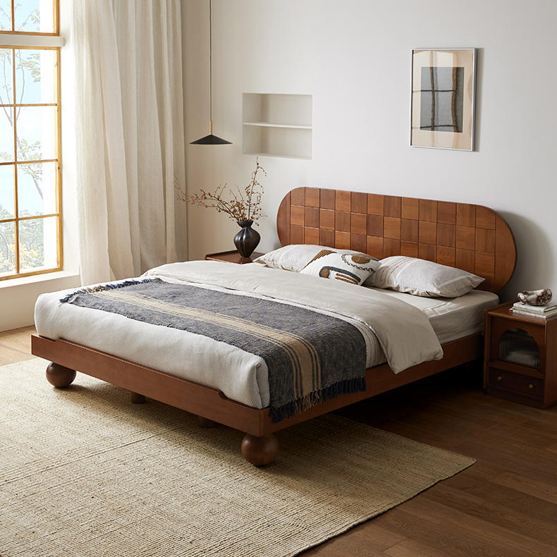 Wooden bed with white bedding and a woven headboard in a well-lit bedroom.