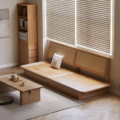 Wooden bed with wicker headboard in a room with a window and small table.