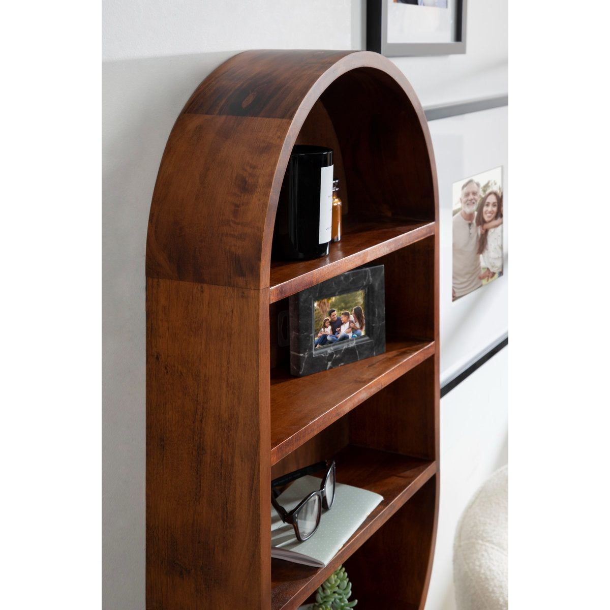 Wooden bookshelf with decorative items against a white wall