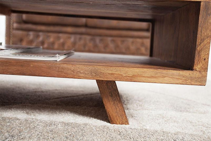 Wooden coffee table with a magazine on a carpeted floor