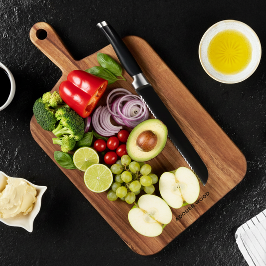 Wooden cutting board with fresh vegetables and a knife on a dark surface
