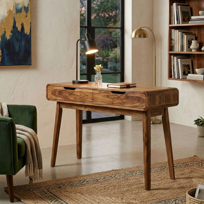 Wooden desk in a home office setting with a lamp, books, and decor items.