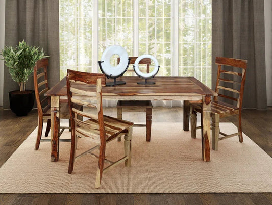 Wooden dining table with four chairs in a room with large windows and curtains.