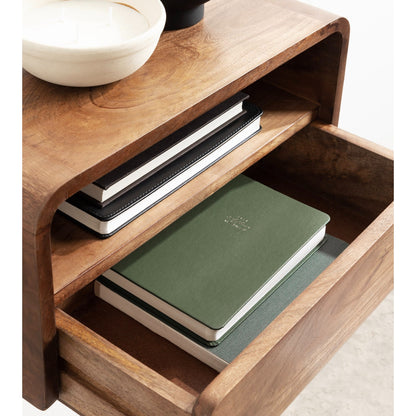 Wooden shelf with notebooks and a bowl on a white background