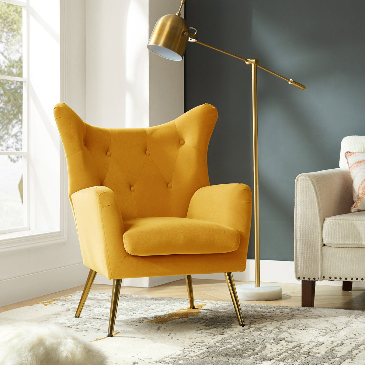 Yellow armchair in a modern living room with a gold floor lamp and gray wall.