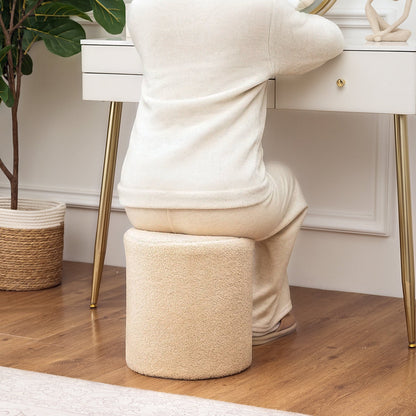 Person using a beige footstool in a home setting with a desk and plant in the background.