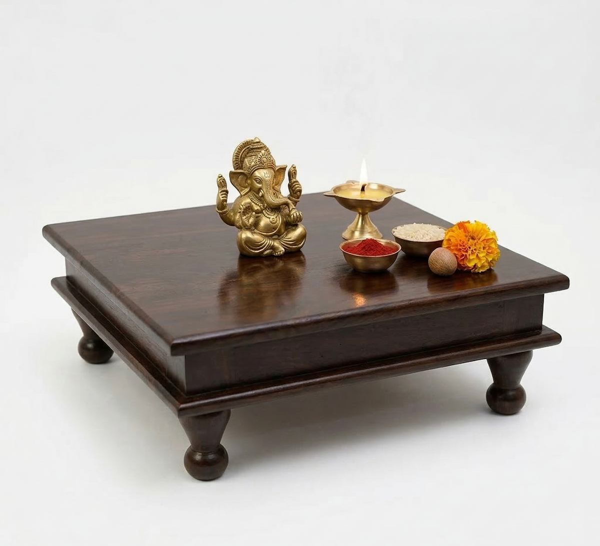 Wooden altar with gold deity statue, candles, and flowers on a white background